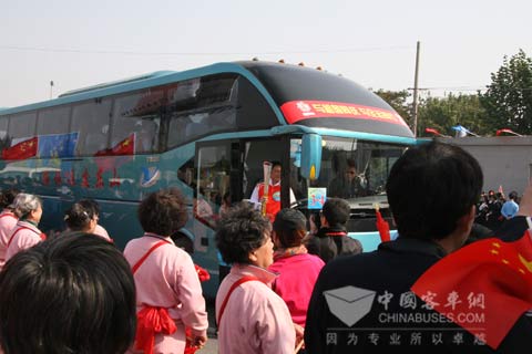 Torch bearer is walking out of Yutong bus with touch 