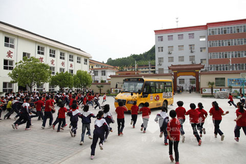 The children happily run to Higer school bus