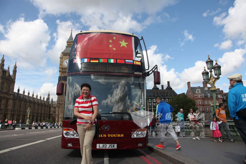 The tourist is standing before Ankai double decker bus